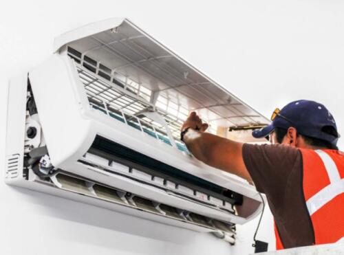 Young repairman fixing a ductless minisplit air conditioning system